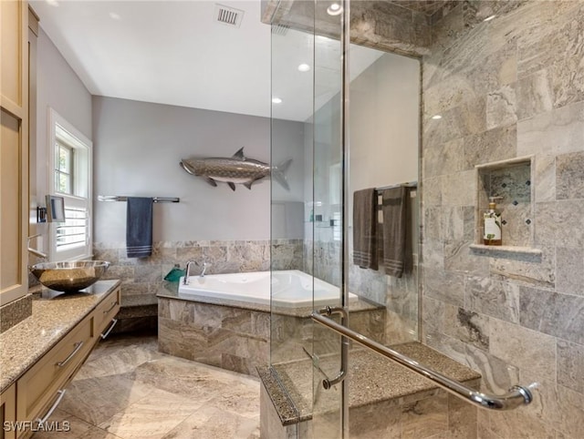 bathroom featuring a garden tub, tile walls, visible vents, a stall shower, and vanity