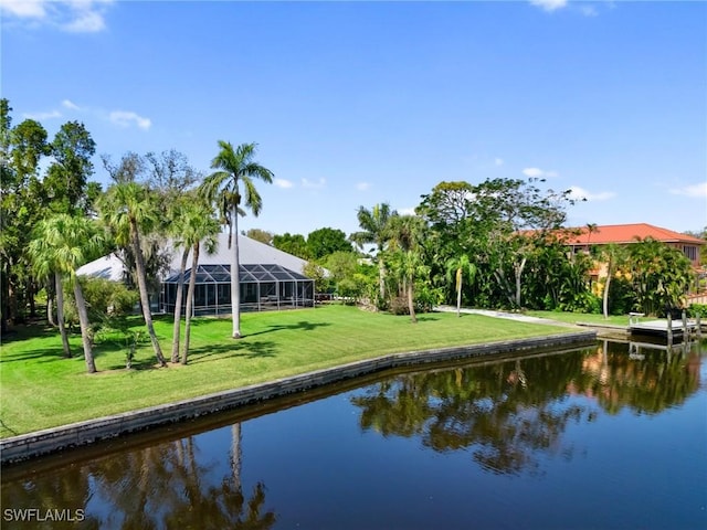 exterior space with a lawn, a water view, and a lanai