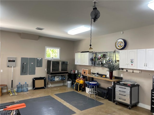 garage with electric panel, visible vents, and baseboards