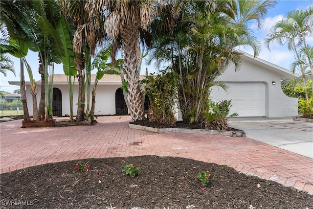 view of front facade featuring driveway, an attached garage, and stucco siding