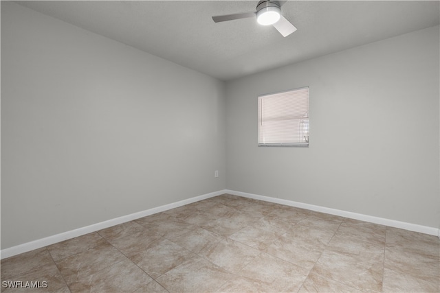 spare room featuring ceiling fan and baseboards