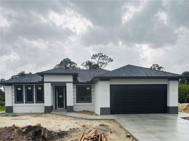 1821 Hines Ave, Lehigh Acres, FL 33972 - view of front of property featuring stucco siding, a garage, roof with shingles, and driveway