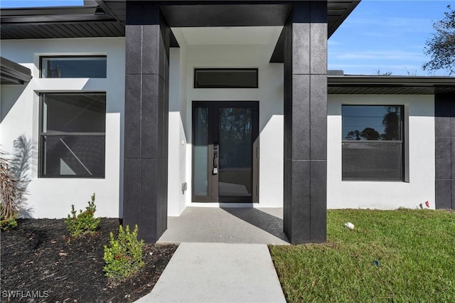 doorway to property with a yard and stucco siding