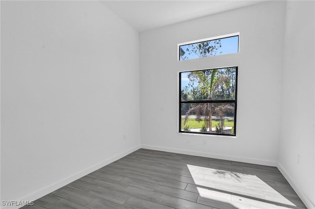 empty room with baseboards and wood finish floors