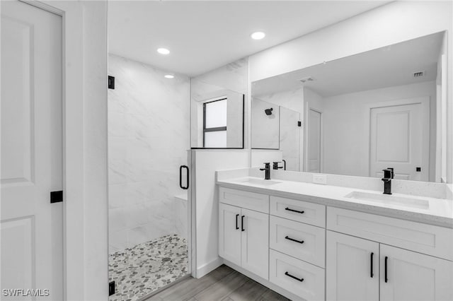 bathroom with a stall shower, a sink, recessed lighting, and double vanity