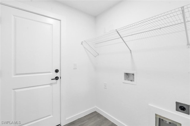 laundry area with hookup for a washing machine, electric dryer hookup, wood finished floors, laundry area, and baseboards