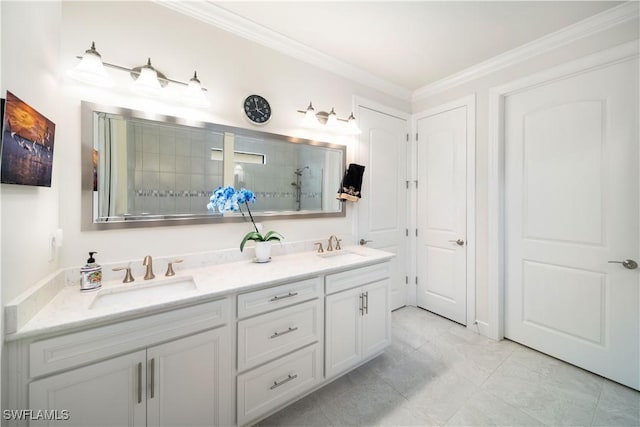 full bath featuring ornamental molding, a tile shower, and a sink