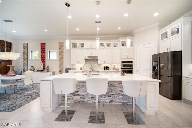 kitchen with a breakfast bar, light countertops, visible vents, black fridge with ice dispenser, and backsplash