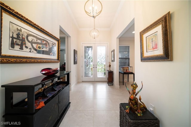 entryway featuring french doors, light tile patterned floors, an inviting chandelier, ornamental molding, and baseboards