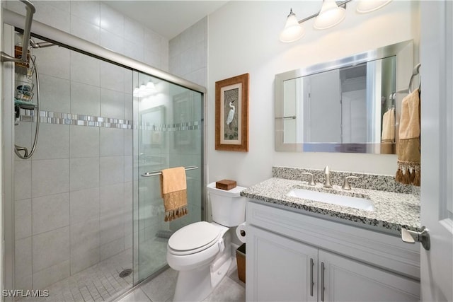 bathroom with toilet, a stall shower, and vanity