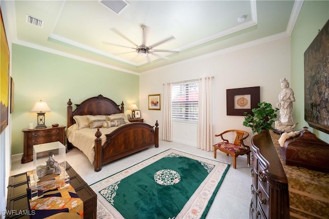 bedroom featuring light tile patterned floors, visible vents, a tray ceiling, and ornamental molding