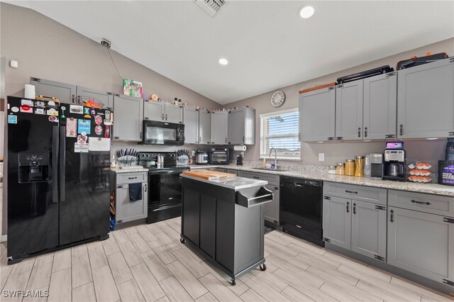 5011 Dania Cir, Labelle, FL 33935 - kitchen featuring visible vents, a center island, vaulted ceiling, black appliances, and a sink
