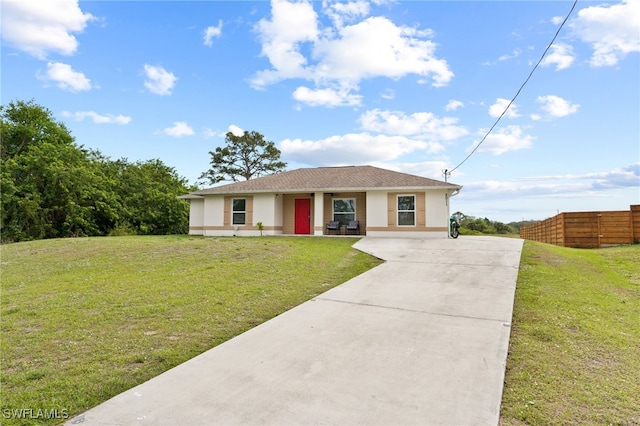 5011 Dania Cir, Labelle, FL 33935 - ranch-style home with concrete driveway, a front lawn, fence, and stucco siding