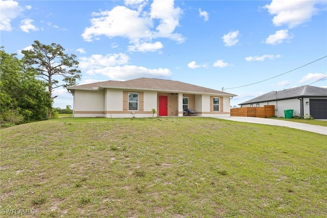 view of front of house featuring a front lawn, fence, and stucco siding