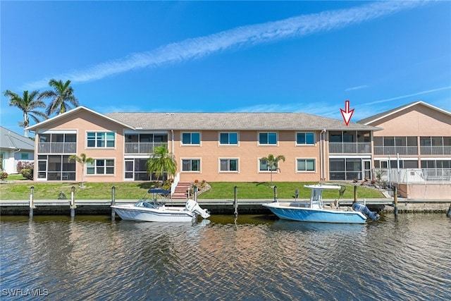 view of dock with a yard and a water view