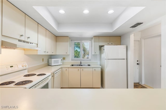 kitchen with white appliances, under cabinet range hood, and cream cabinetry