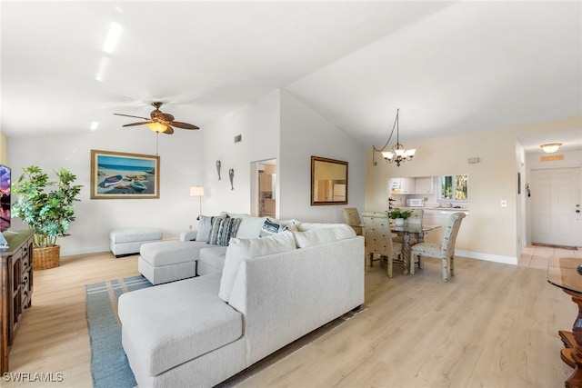 living room featuring vaulted ceiling, light wood-style flooring, and baseboards