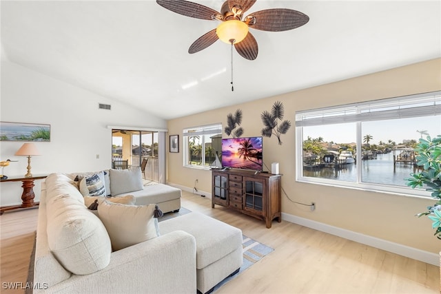 living room with light wood-style flooring, a ceiling fan, visible vents, vaulted ceiling, and baseboards