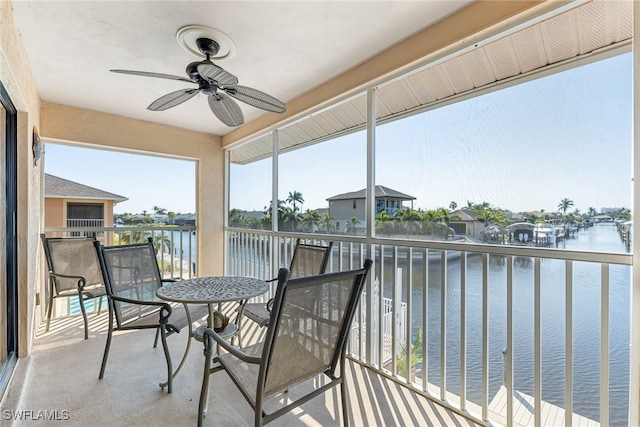 sunroom with a water view and a ceiling fan