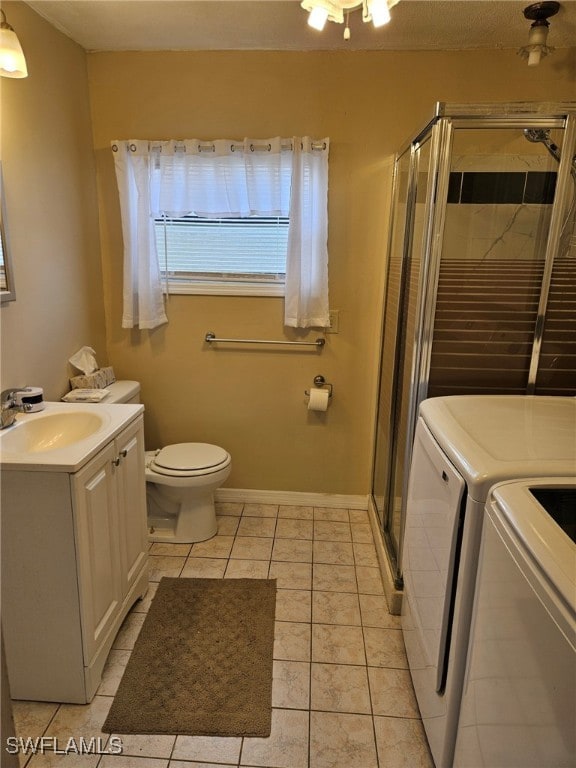 full bath featuring washing machine and dryer, toilet, a stall shower, tile patterned floors, and vanity