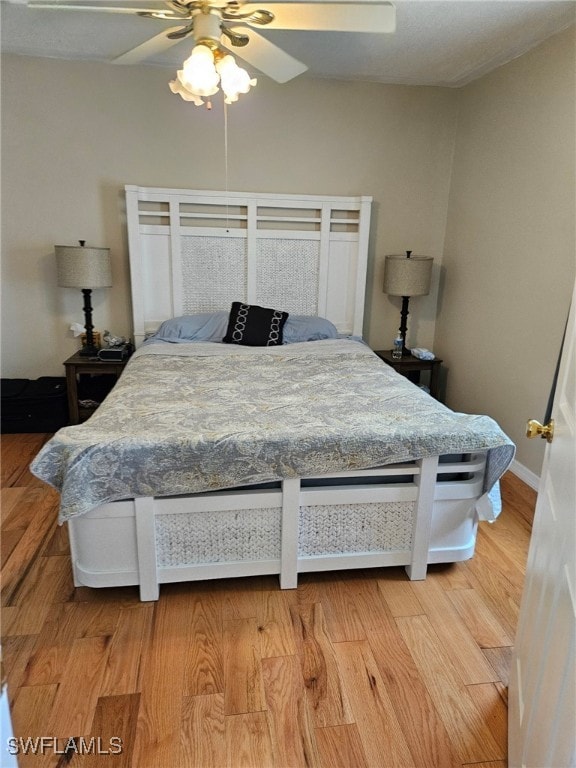 bedroom with baseboards, light wood finished floors, and ceiling fan