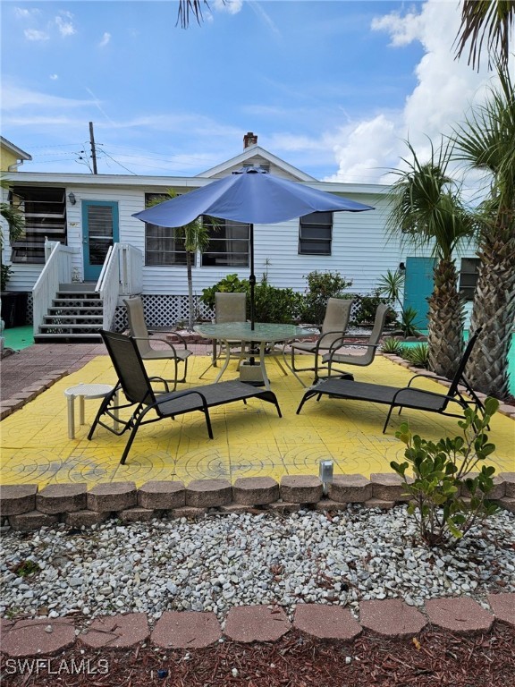 back of property with a deck and a patio area