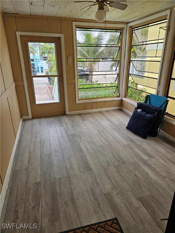 unfurnished sunroom featuring a ceiling fan