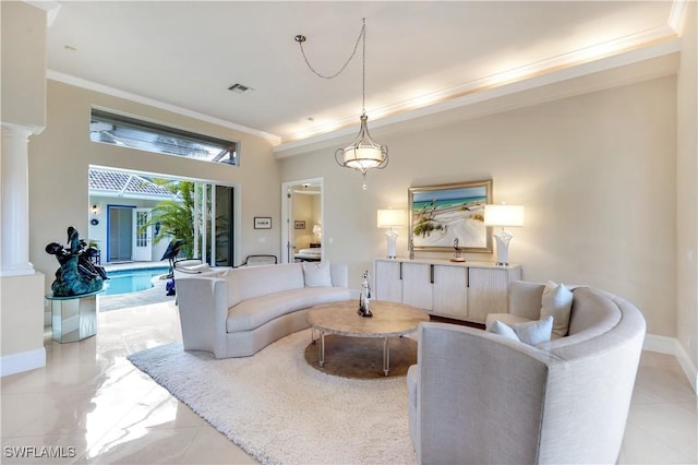 living area with ornate columns, visible vents, baseboards, and crown molding