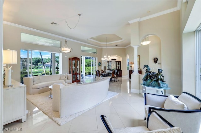 living area featuring visible vents, ornamental molding, decorative columns, an inviting chandelier, and arched walkways