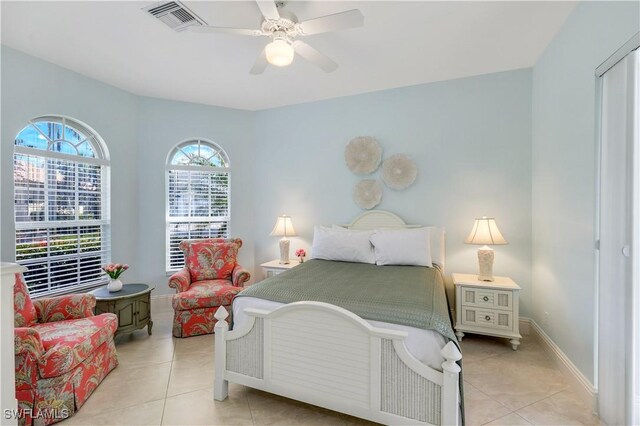 bedroom featuring light tile patterned floors, baseboards, visible vents, and a ceiling fan