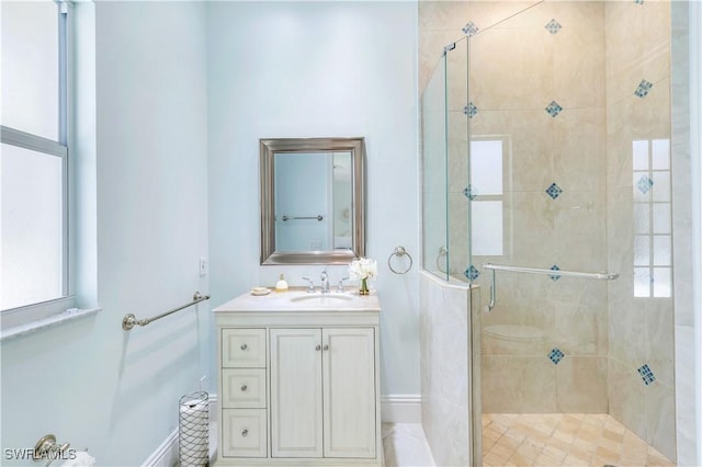 bathroom with a stall shower, vanity, and baseboards