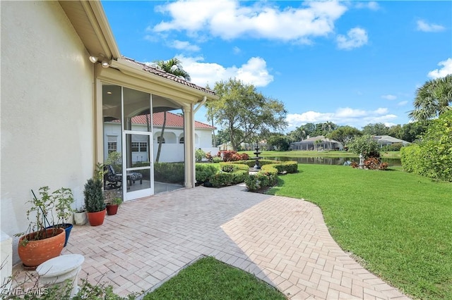view of patio with a water view and a sunroom