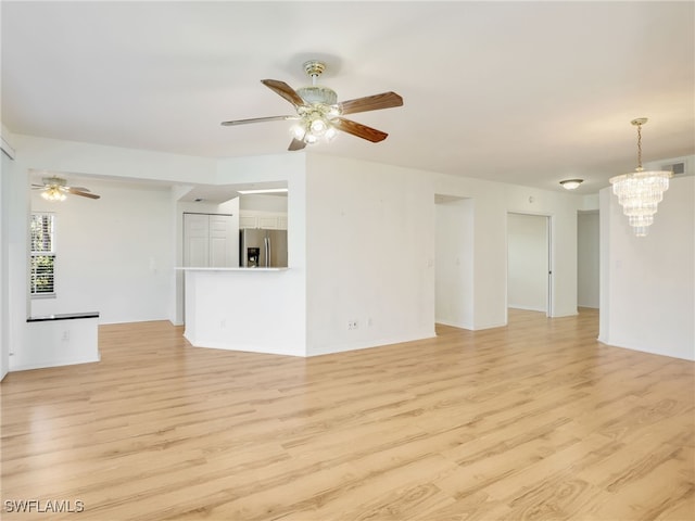 unfurnished living room with light wood-style floors, visible vents, and ceiling fan with notable chandelier