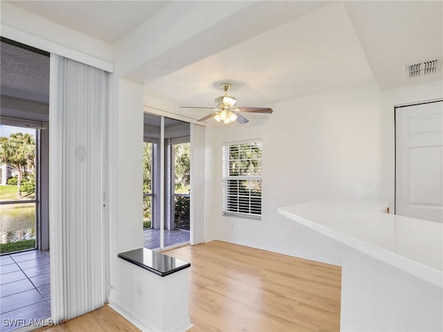 entrance foyer with baseboards, ceiling fan, visible vents, and wood finished floors