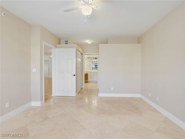 empty room with ceiling fan, visible vents, and baseboards