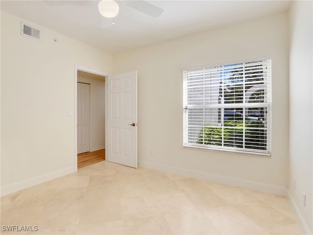 unfurnished room featuring ceiling fan, visible vents, and baseboards