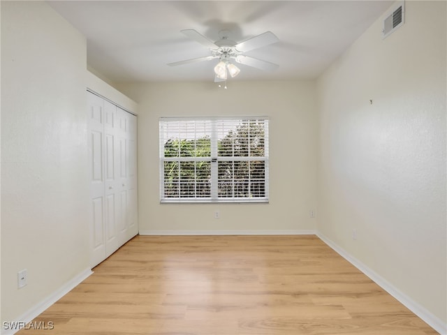 unfurnished bedroom featuring baseboards, visible vents, ceiling fan, light wood-type flooring, and a closet