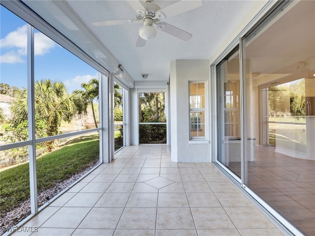 unfurnished sunroom featuring a healthy amount of sunlight and ceiling fan