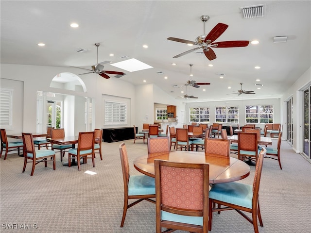 dining area featuring light carpet, plenty of natural light, visible vents, and lofted ceiling