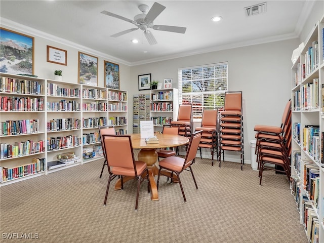 dining area featuring carpet floors, a ceiling fan, visible vents, and crown molding