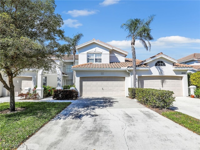 view of front of property with a garage, concrete driveway, a tile roof, and stucco siding