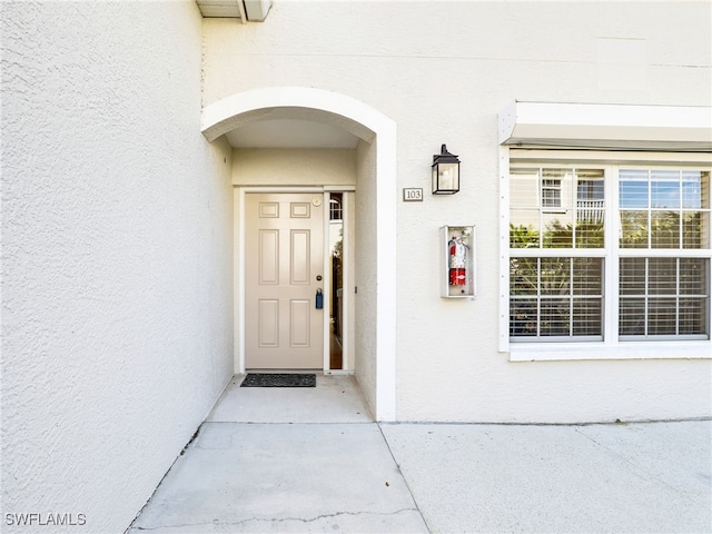 doorway to property featuring stucco siding