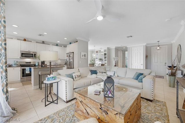 living room with ceiling fan, ornamental molding, visible vents, and light tile patterned flooring