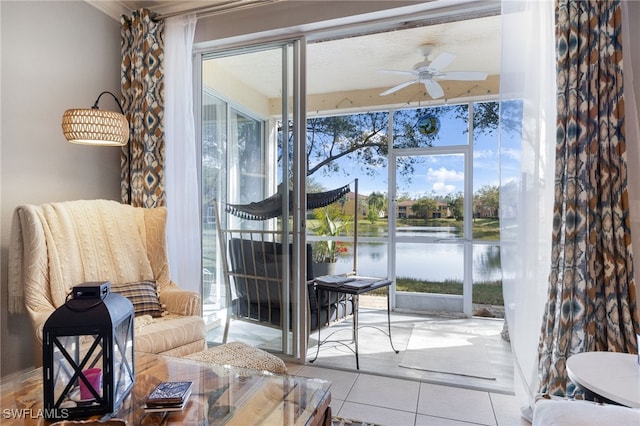 doorway with a ceiling fan, tile patterned floors, a water view, and plenty of natural light