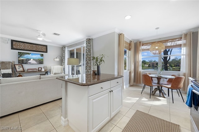 kitchen with white cabinetry, visible vents, light tile patterned flooring, and ornamental molding