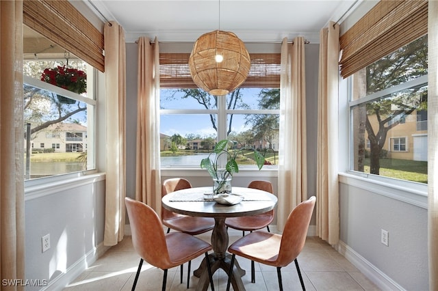 dining area with light tile patterned floors, a healthy amount of sunlight, and a water view