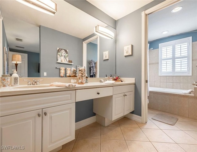 full bathroom with double vanity, a relaxing tiled tub, a sink, tile patterned floors, and visible vents