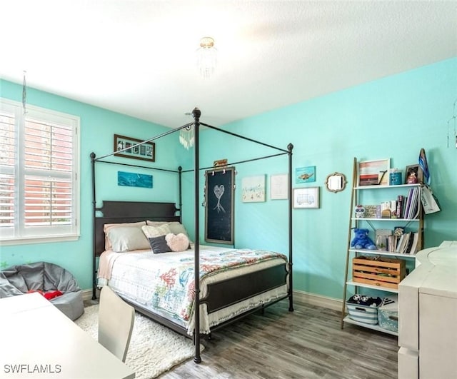 bedroom with baseboards and wood finished floors