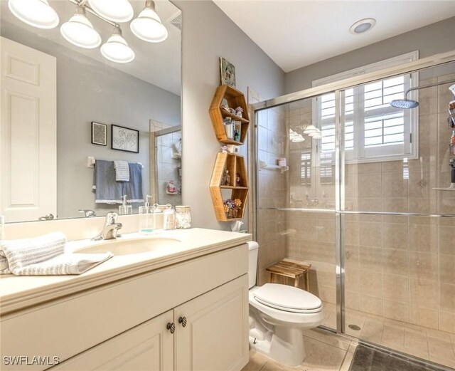 full bathroom with a shower stall, tile patterned flooring, vanity, and toilet