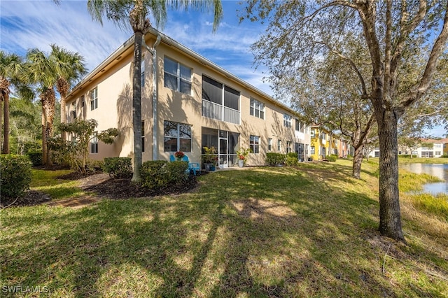 back of property with stucco siding, a residential view, and a lawn